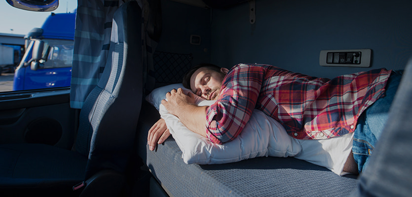 Truck driver resting in a sleeper berth while checking ELD hours
